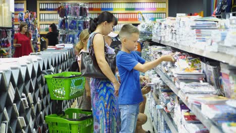 vinnitsa, ukraine - august 20, 2018: shopping for school. boy buying different products in stationery shop.