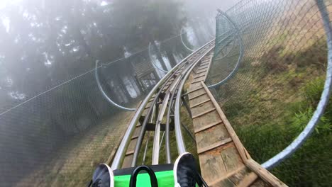 First-person-view-of-a-summer-toboggan-run-trough-a-foggy-forrest-in-Germany-in-4K