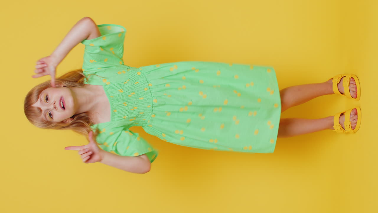 Bambina bionda birichina che fa smorfie divertenti, giocando e mostrando la lingua