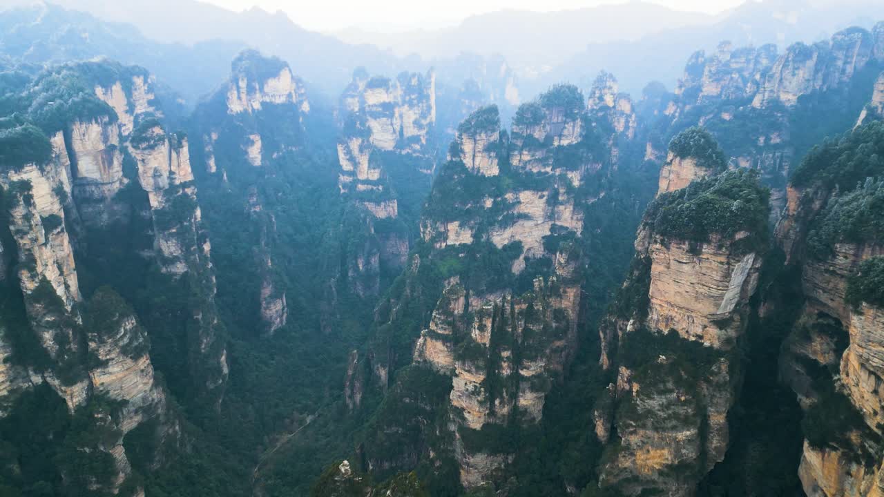 fotografía aérea que muestra los pilares dentro del parque nacional de zhangjiajie con un aspecto brumoso