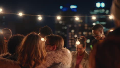 happy multiracial friends having fun dancing playfully together enjoying rooftop party at night laughing celebrating friendship