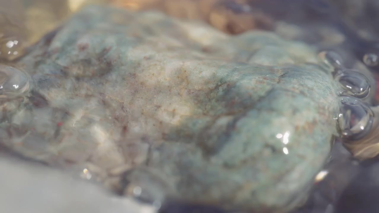 Primo piano di una roccia coperta dall'acqua del ruscello