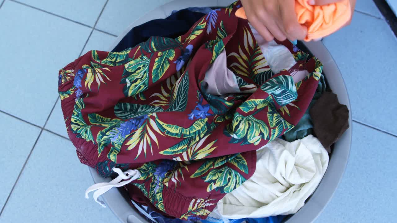 여자 가 세탁소 4k 에서 세탁기 에 옷 을 넣고 있다