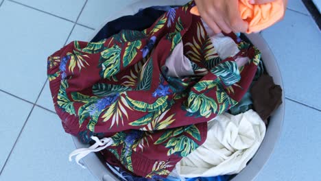 mujer poniendo ropa en la lavadora en la lavandería 4k