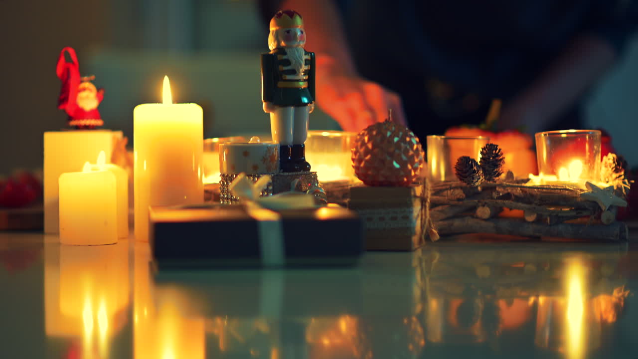 Soft candlelight illuminates a festive display featuring a nutcracker, ornaments, and holiday accessories, perfect for creating a welcoming holiday ambiance