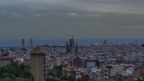 Impresionante-Lapso-De-Tiempo-Del-Día-A-La-Noche-Del-Paisaje-Urbano-De-Barcelona,-Con-Monumentos-Emblemáticos,-Horizontes,-Tráfico,-Transición-Del-Atardecer-A-La-Salida-De-La-Luna-Y-Atmósfera-Urbana