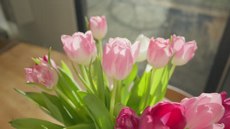 los tulipanes retroiluminados se balancean suavemente en un jarrón en un día soleado, en primer plano con un movimiento de dolly-out