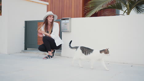 woman and cat in front of a house