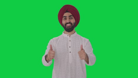 hombre indio sikh feliz mostrando los pulgares hacia arriba pantalla verde