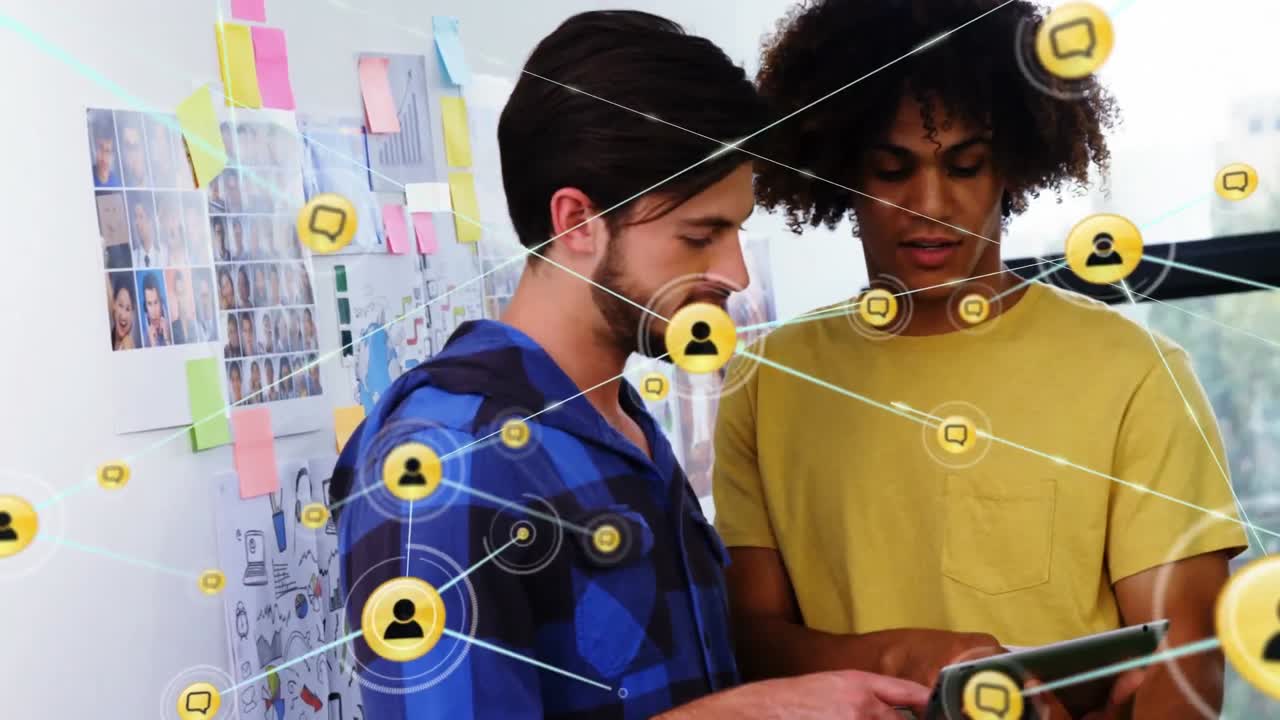 animación de una red de iconos digitales sobre dos hombres diversos discutiendo sobre una tableta digital en la oficina
