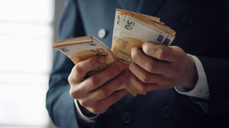 Gros plan sur un homme d'affaires comptant des billets en euros. Mains d'homme tenant de la monnaie européenne.
