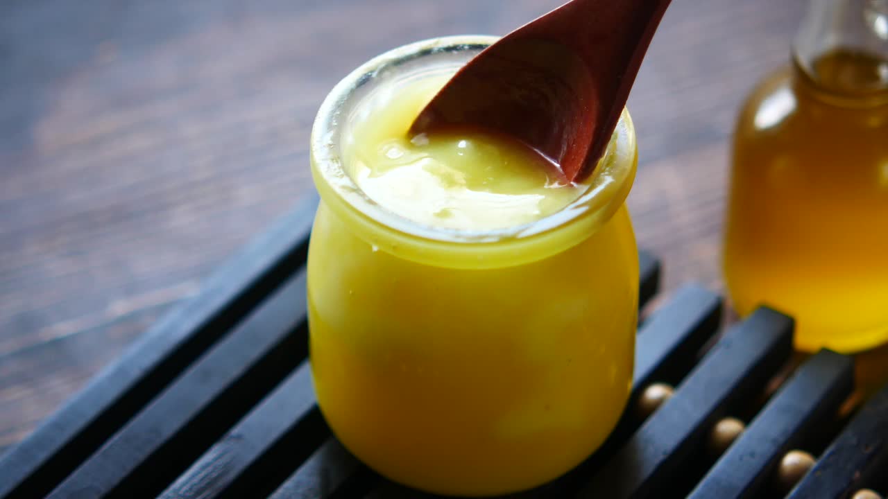 Ghee in a Glass Jar with Wooden Spoon