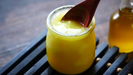 ghee en un frasco de vidrio con cuchara de madera