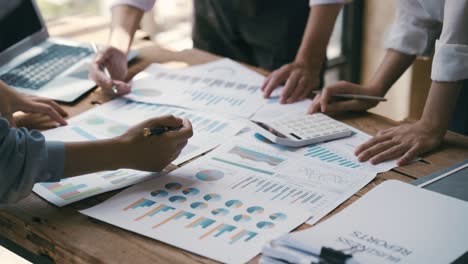 business professionals working together at office desk, hands close up pointing out financial data on a report, teamwork concept. financial and investment.