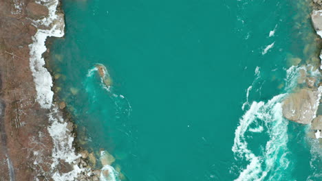 Aerial-shot-of-swirling-water-hitting-rocks-and-rapids