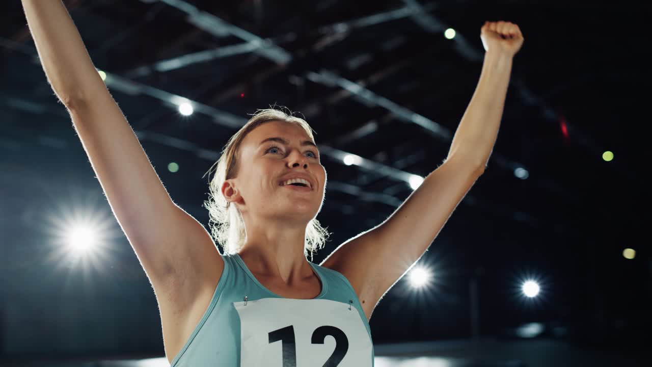 Portrait of Professional Female Athlete Happily Celebrating New Record on a Sport Championship. Determined Successful Sportswoman Raising Arms after Winning Gold Medal. Static Medium Shot