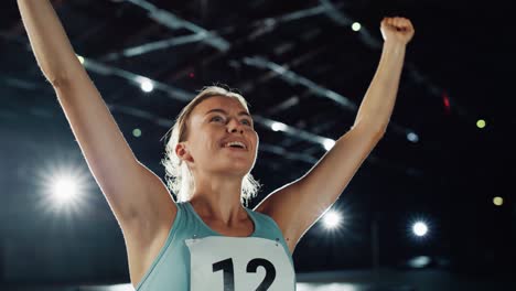 portrait of professional female athlete happily celebrating new record on a sport championship. determined successful sportswoman raising arms after winning gold medal. static medium shot