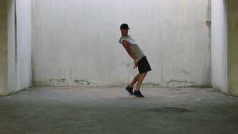 Hombre-Bailando-Joven-Talentoso-Bailarín-Callejero-Breakdance-Realizando-Varios-Movimientos-De-Baile-De-Estilo-Libre-En-Forma-De-Hombre-De-Raza-Mixta-Practicando-En-Un-Almacén-Sucio