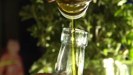 un hombre vierte aceite de oliva en una botella
