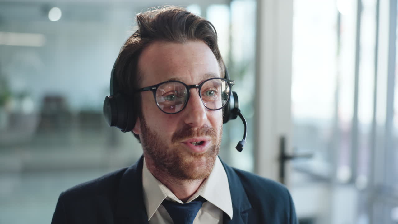 Pria Profesional Berheadset Berbicara dan Tersenyum di Kantor