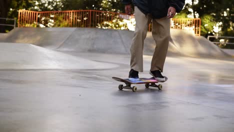 Skater-Irreconocible-Saltando-Y-Haciendo-Flip-360-Con-Su-Tablero-Y-Salpicando-La-Arena-Colorida-De-Su-Tablero