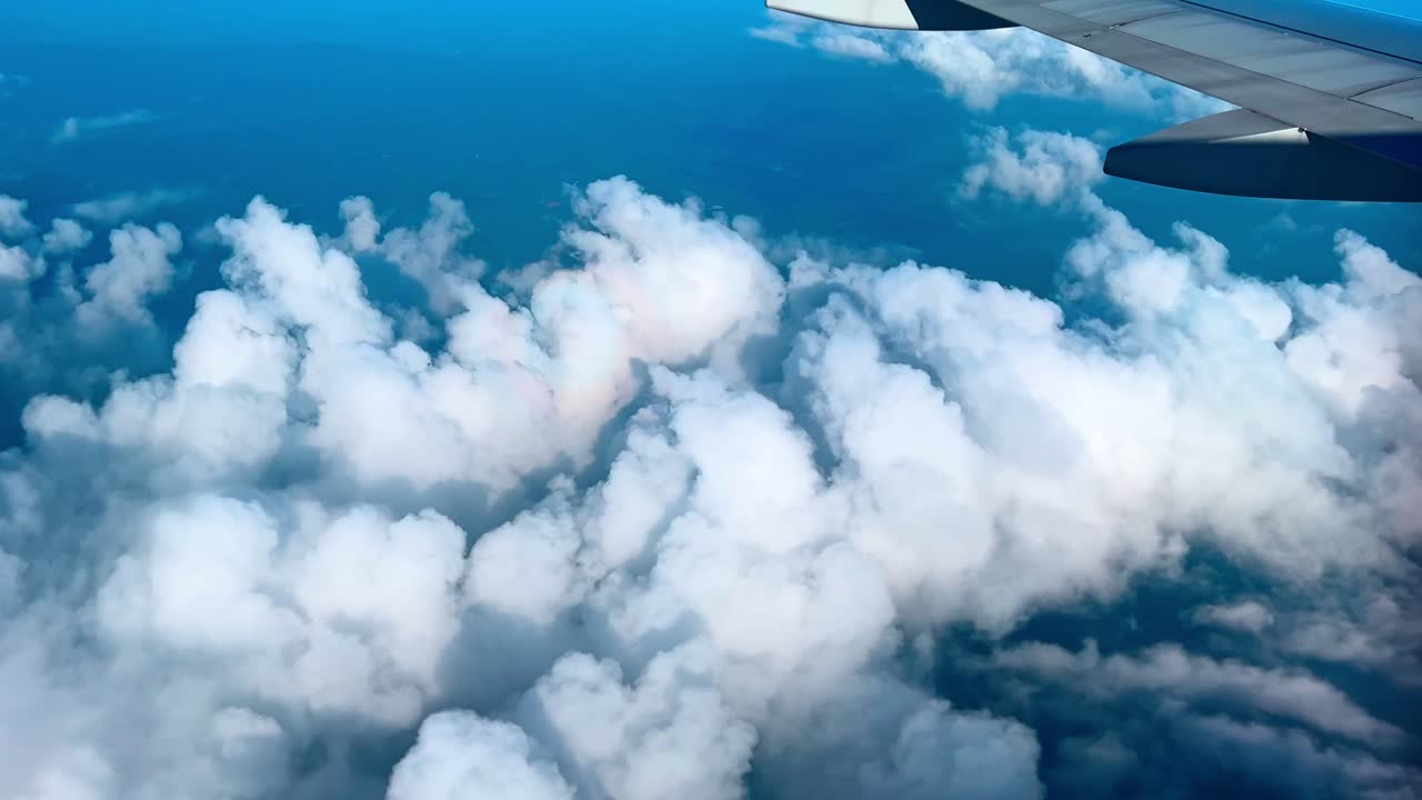 Airplane wing and breathtaking cloudscape from window seat—ideal for travel, flight, aviation, and sky-themed visuals