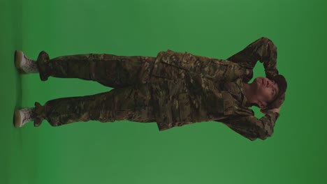 full body of distressed asian male soldier holding his head having headache while protecting his country from the war on the green screen background