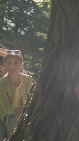 people hiding behind a tree in a park