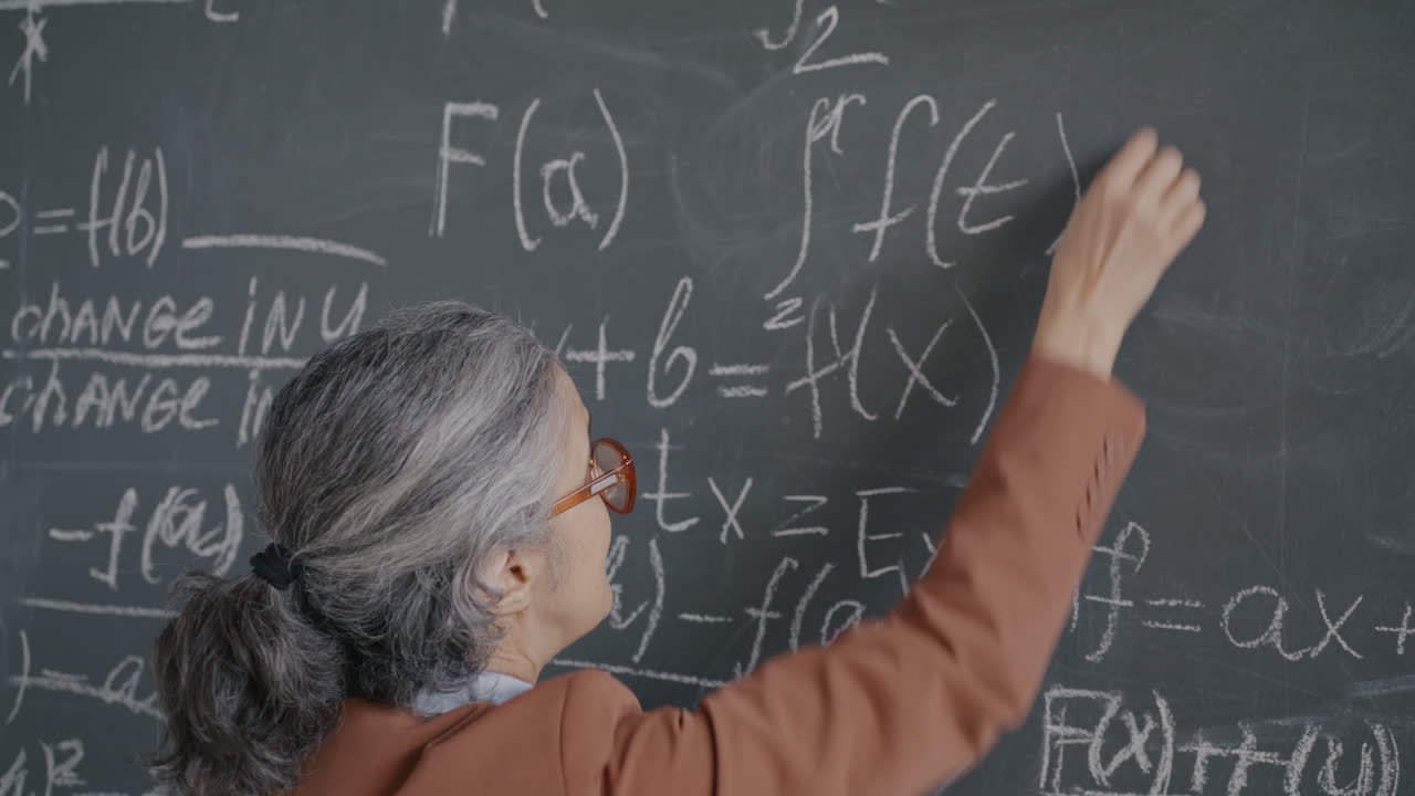 Professor Writing Equations on a Blackboard