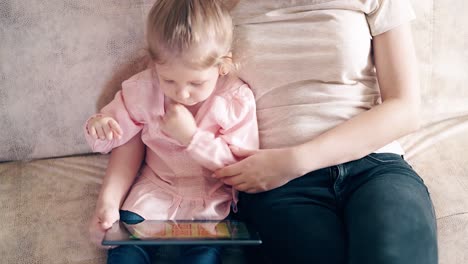 High-angle-shot-CU-4k-Young-attractive-mother-and-sweet-daughter-are-sitting-on-the-couch