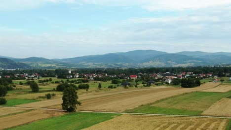 landscape aerial view of villages and fields with mountains and blue sky in the background