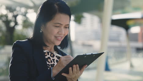 businesswoman writing outdoors