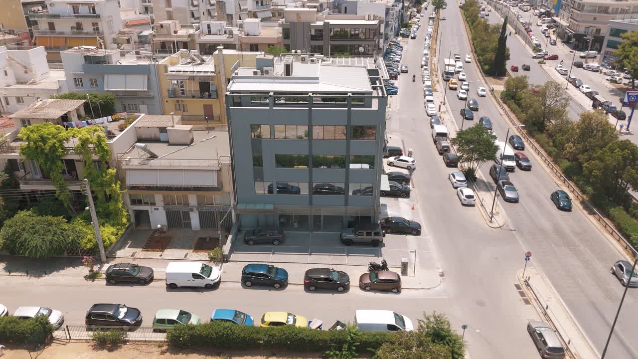 Yaz aylarında işlek bir yolun kenarında modern bir bina, Atina şehir manzarası
