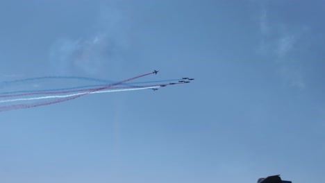 the patrouille de france, the aerobatic demonstration unit of the french air force, performs a flyover in tight formation, trailing red, white, and blue smoke across the sky