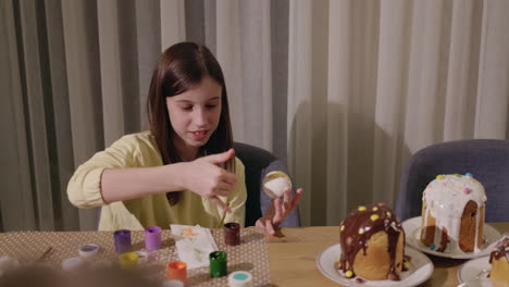 girl decorating easter eggs and bread