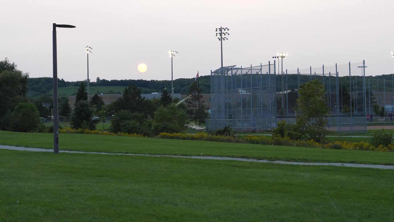 지역 공원 야구 다이아몬드와 고등학교를 통해 여름 저녁에 일몰