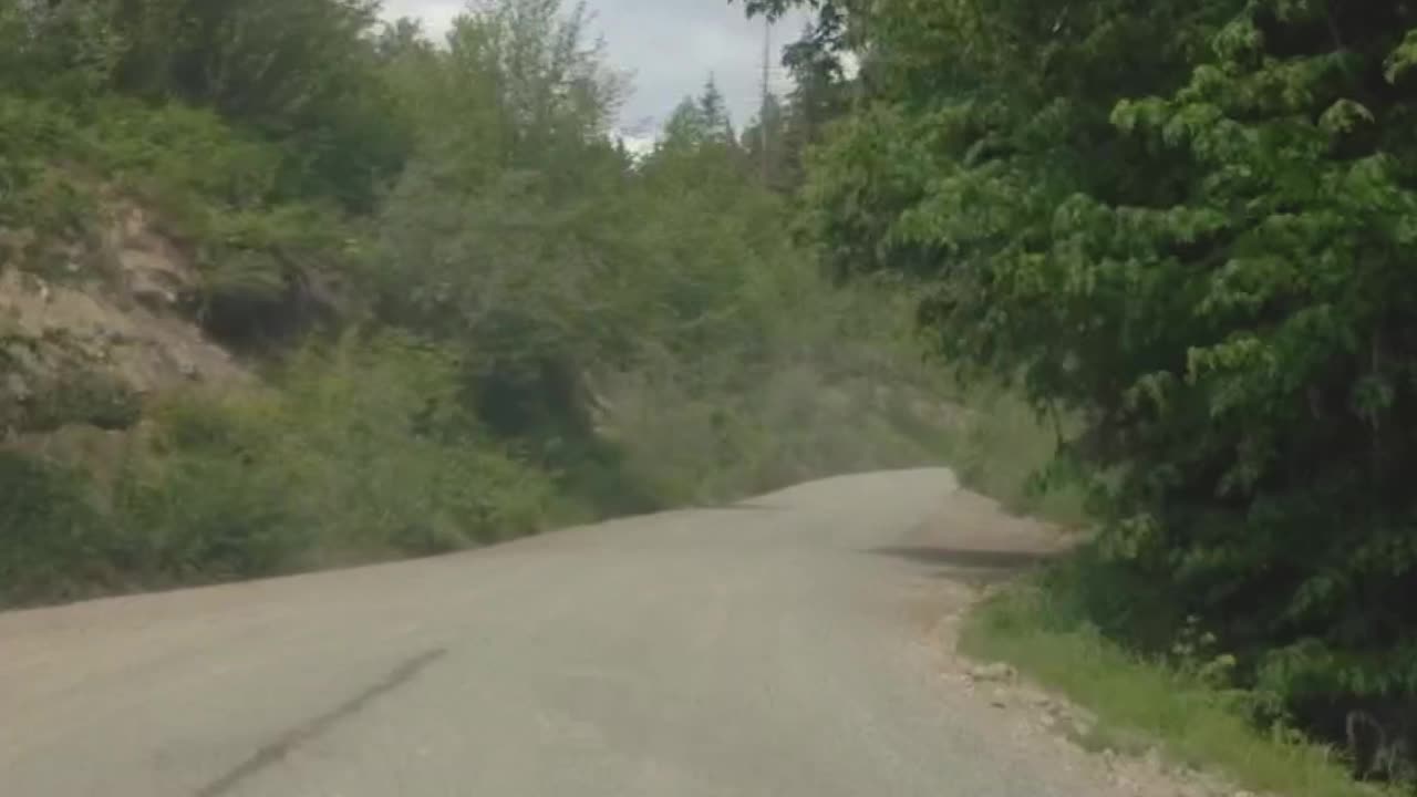 POV driving on a dirt road through trails in forest mountainous terrain off road jeep sport SUV