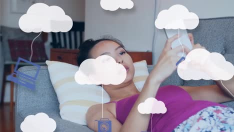 animación de nubes e iconos de medios sobre una mujer usando un teléfono inteligente