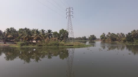 scenic landscape waterway with palm trees and powerlines in alappuzha in india