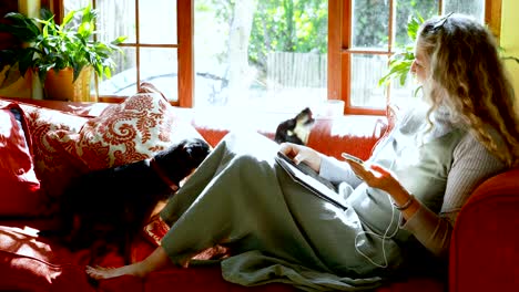 mujer madura jugando con su perro en la sala de estar 4k
