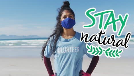 animación de texto verde y logotipo del globo sobre una mujer hispana con máscara facial en la playa