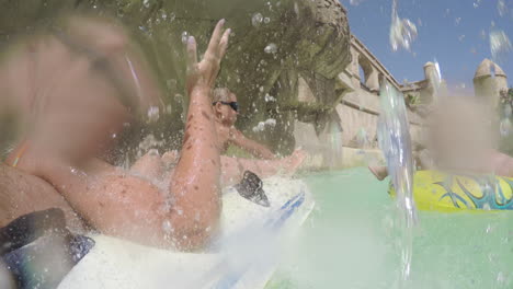 family having lazy river ride in water park