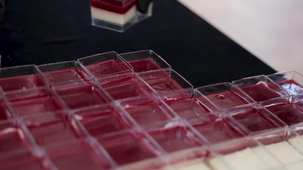 Waiter arranging deserts on catering table next to each other