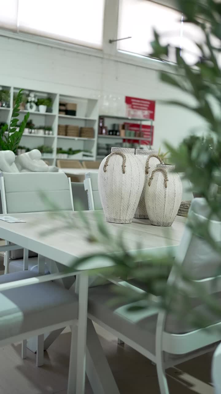Explore a bright interior showcasing a modern table surrounded by chic chairs. The elegant vases add a touch of sophistication to the space, perfect for home decor inspiration
