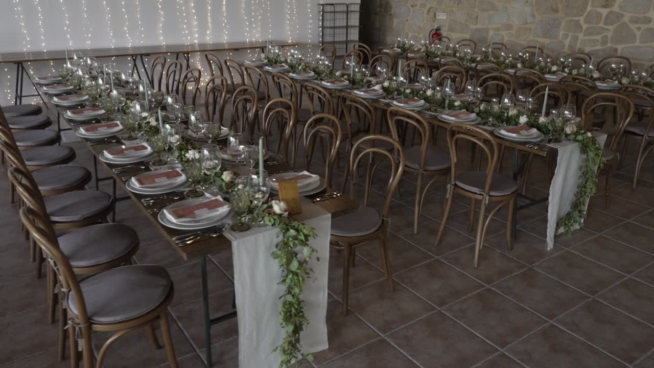 Montaje elegante para evento o recepción de boda con mesas largas y decoración floral