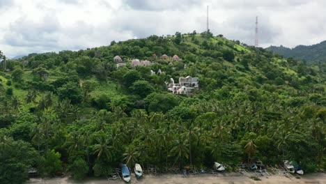 Tropical-island-beach-with-unique-dome-villa-on-mountain-in-Lombok-Indonesia,-aerial