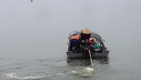 workers rowing boat to collect garbage