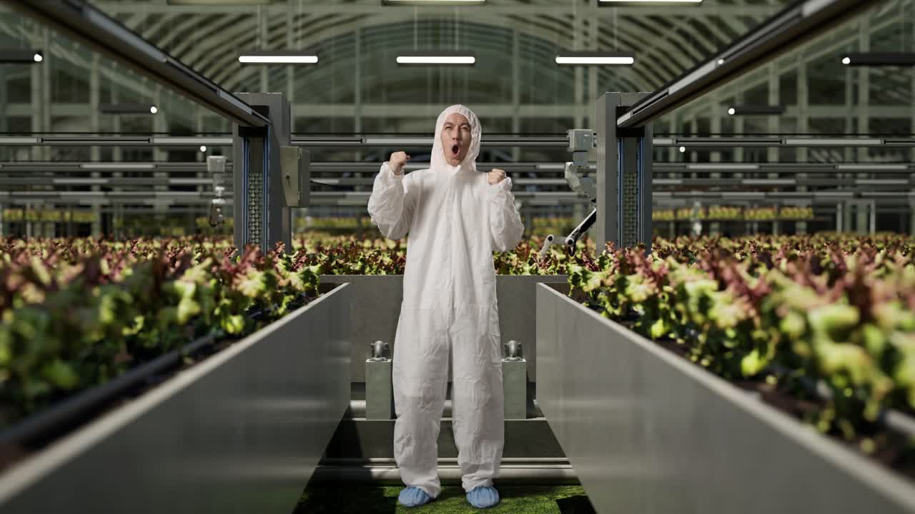 cuerpo lleno de hombre asiático investigador gritando meta celebrando mientras estaba de pie en el invernadero con agricultores robóticos inteligentes