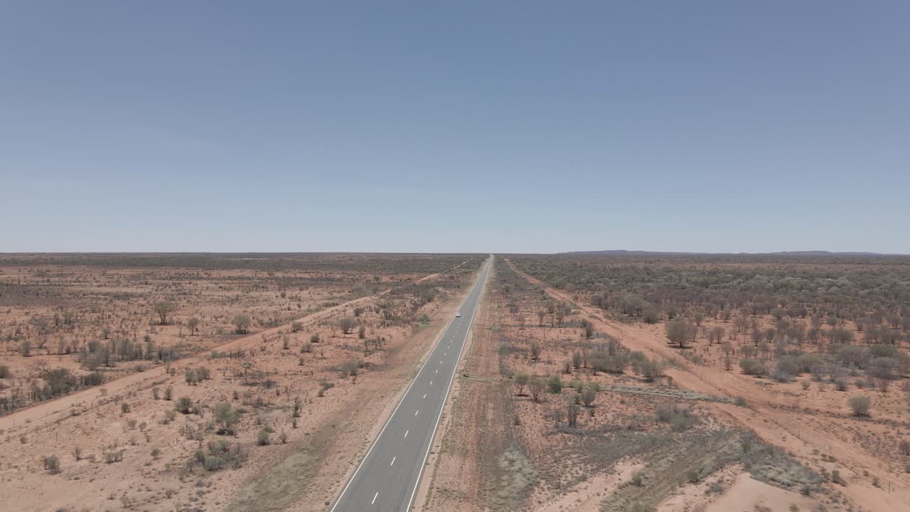 Van Driving On Long And Winding Uluru Road. Northern Territory Of Australia. drone pull-away