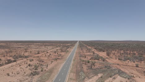 van driving on long and winding uluru road. northern territory of australia. drone pull-away